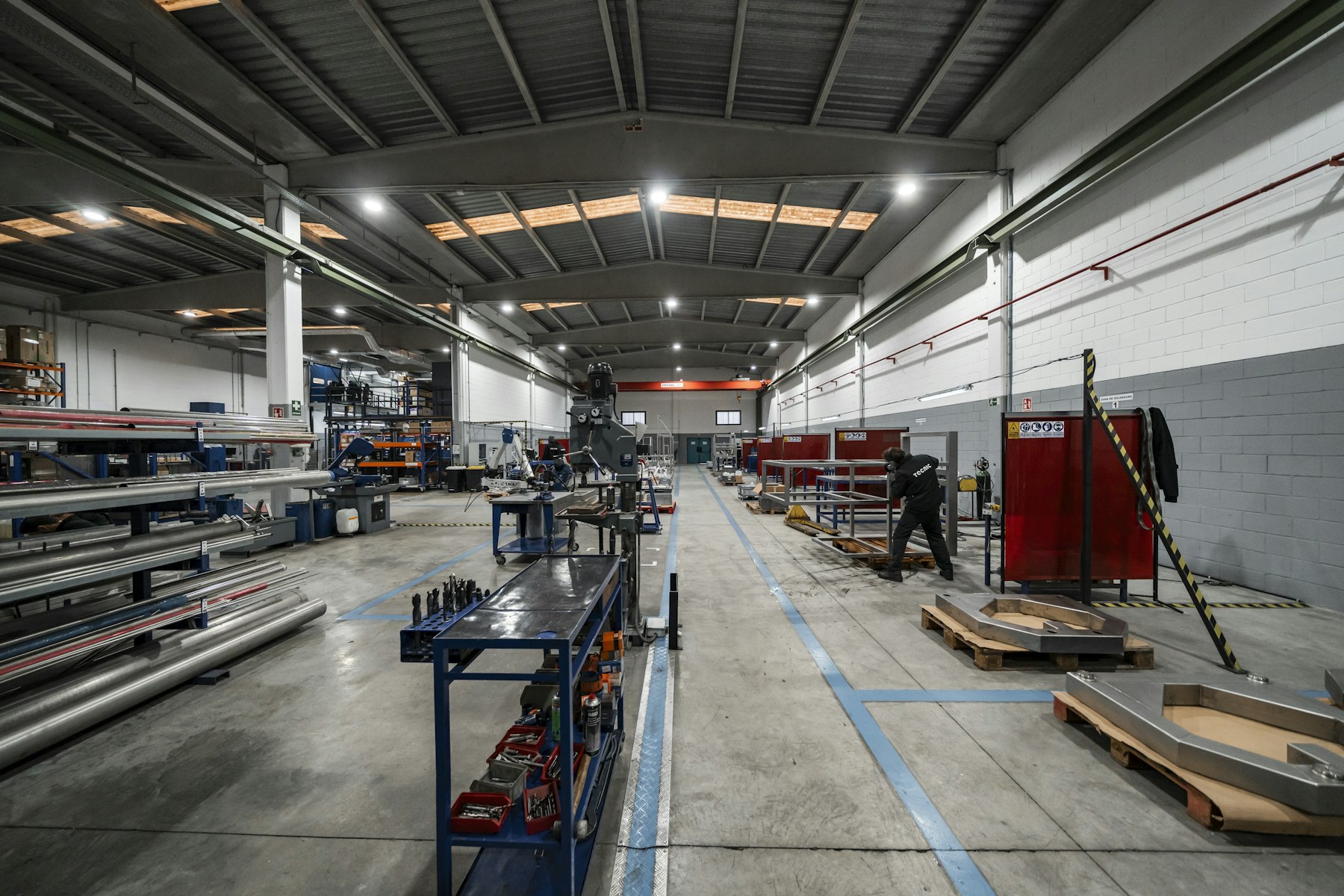 A wide factory interior with equipment and workers